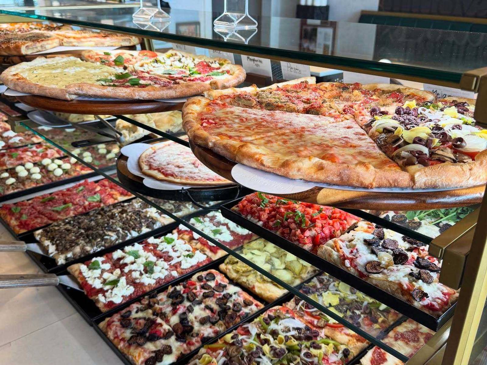 Roman and square pizzas in the case at Baldinucci Pizza Romana