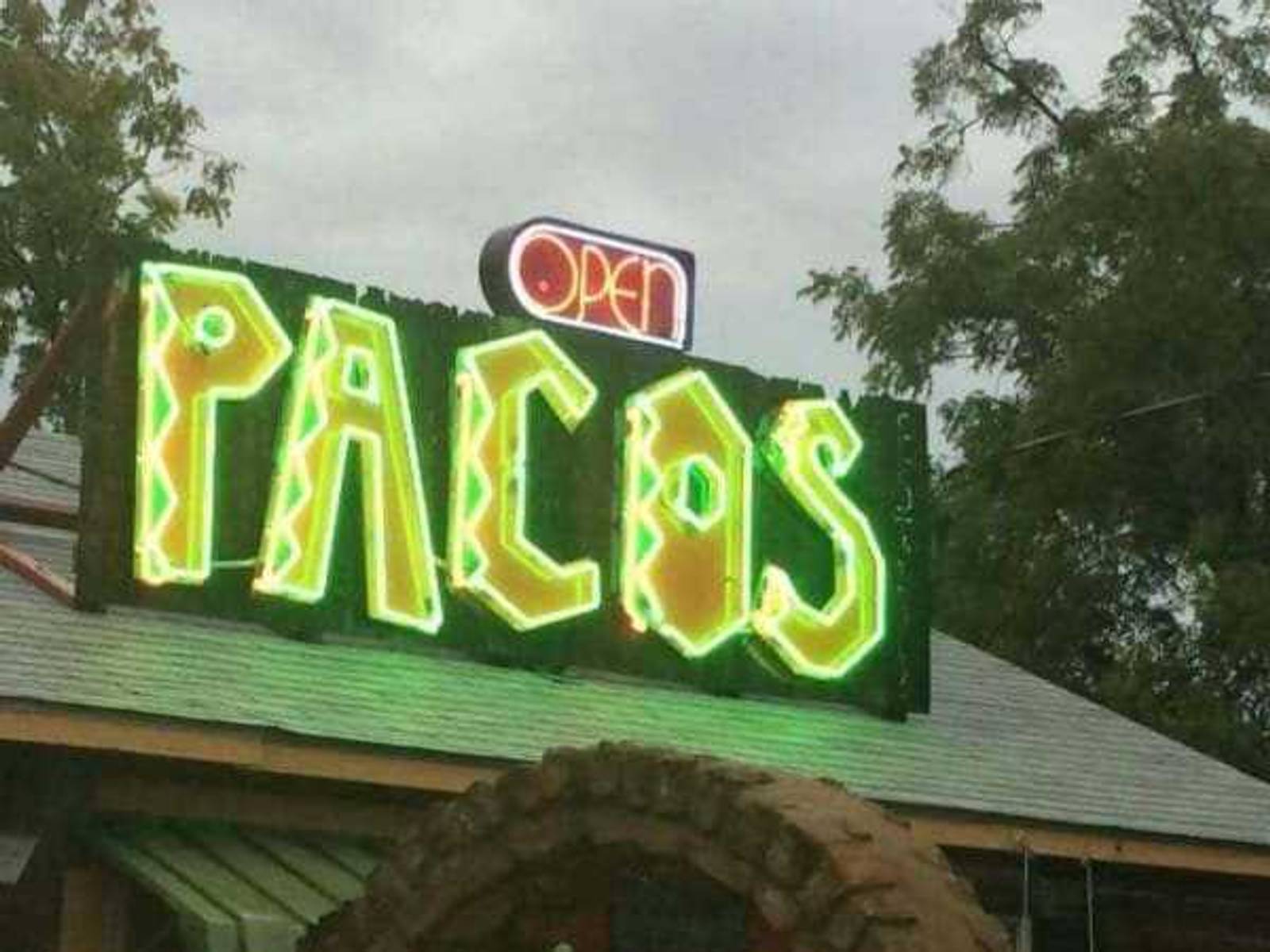 The neon PACOS sign on the roof of Paco’s Tacos