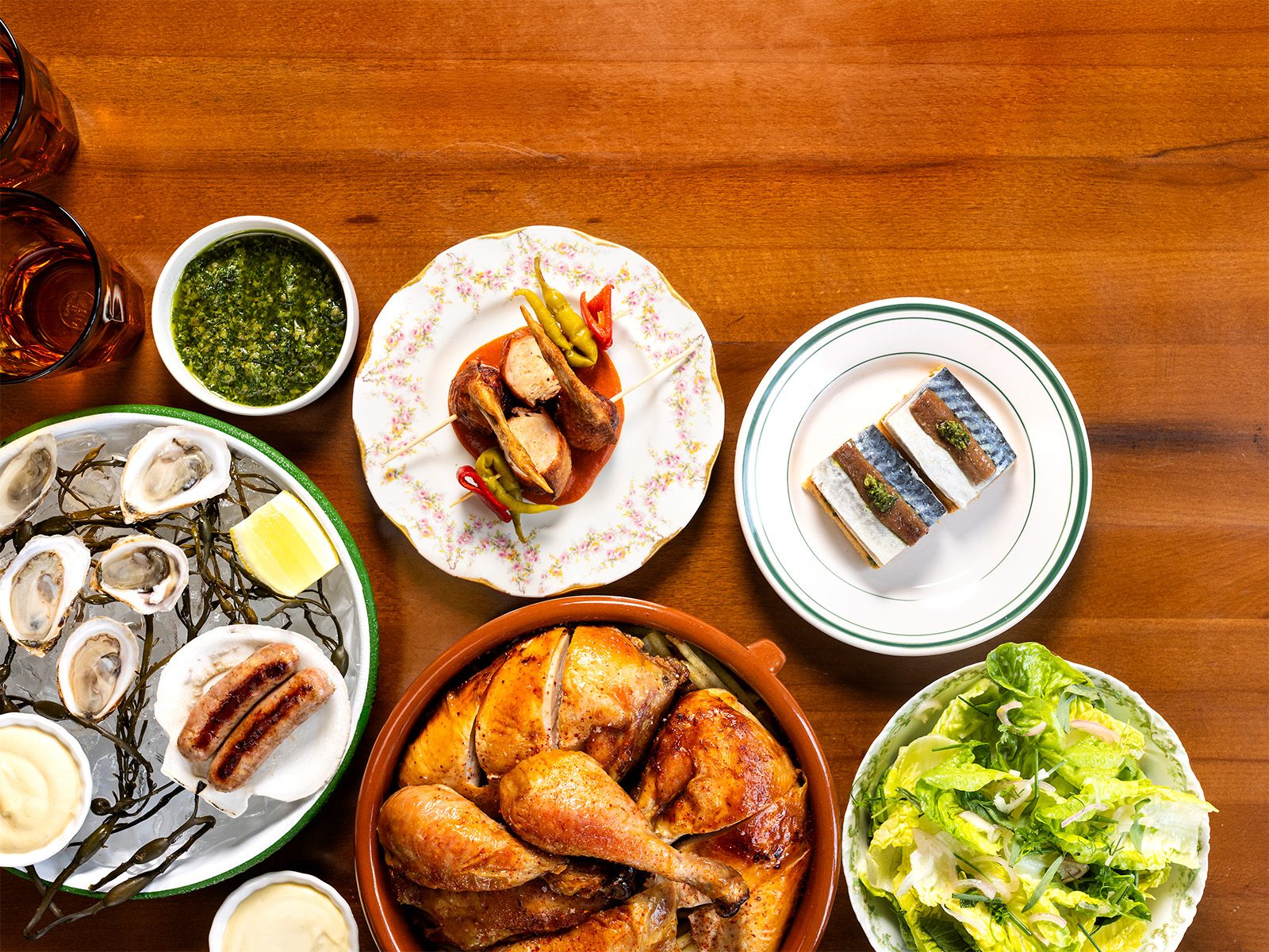 Heretík’s table: rotisserie chicken, oysters and sausages on ice, a green salad, and matrimonios