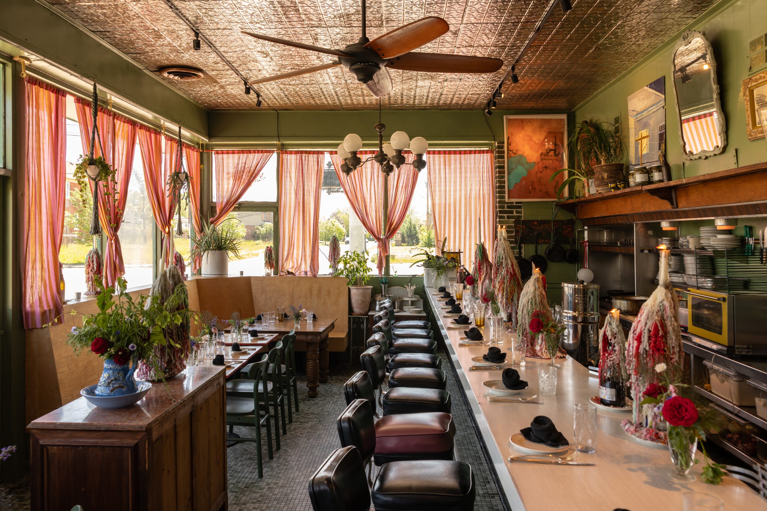 The dining room at Rose’s on East Jefferson: tin ceiling, striped curtains, wax-dripped flowers
