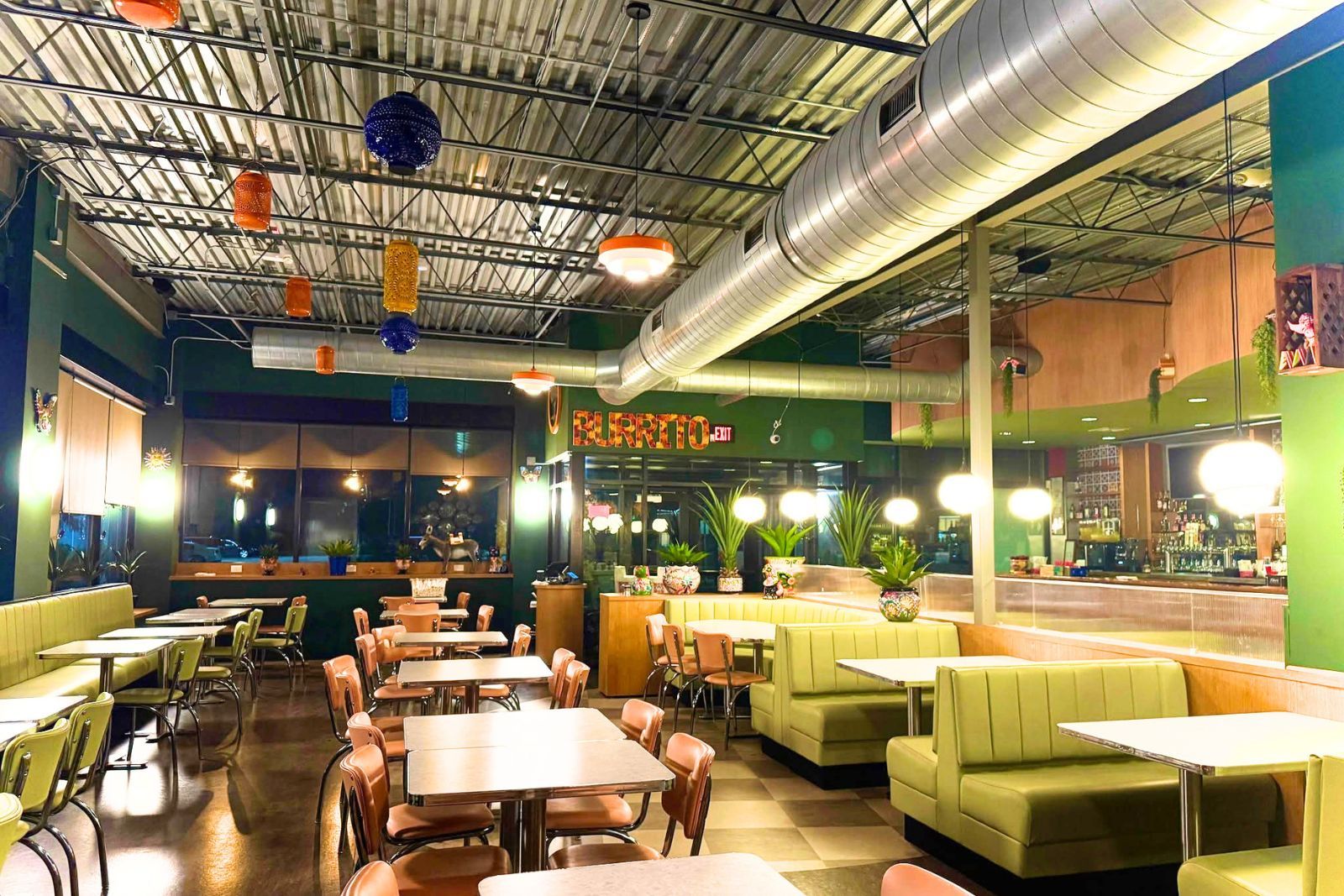 Dining room at El Burrito Grill and Bar, lime-green booths and a patterned BURRITO sign