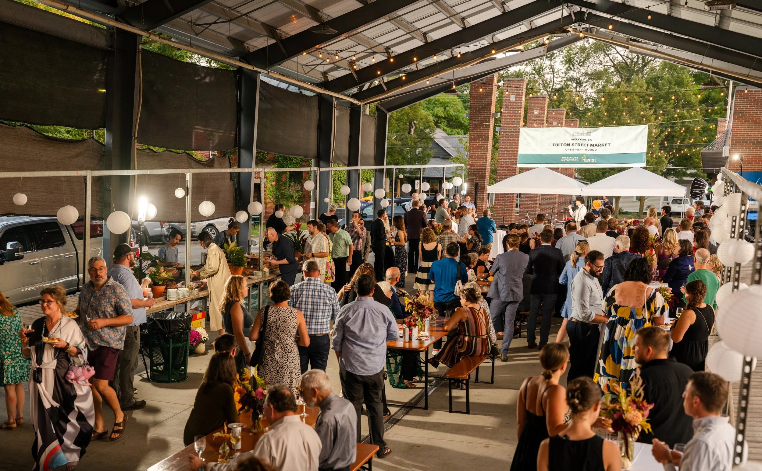 Guests eating under the Fulton Street Market pavilion at A Night at the Market