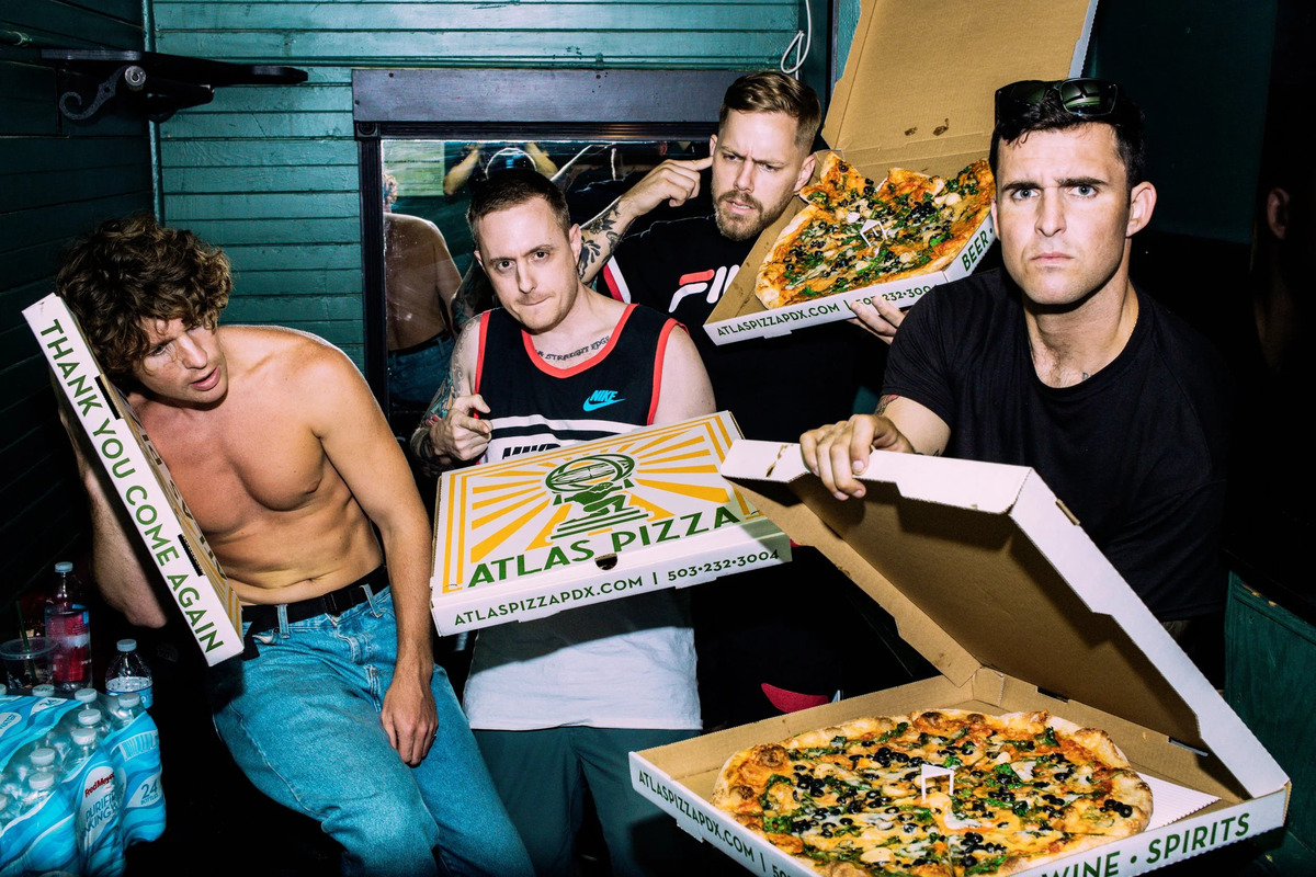 Atlas Pizza boxes and New York-style pies held by the shop’s crew