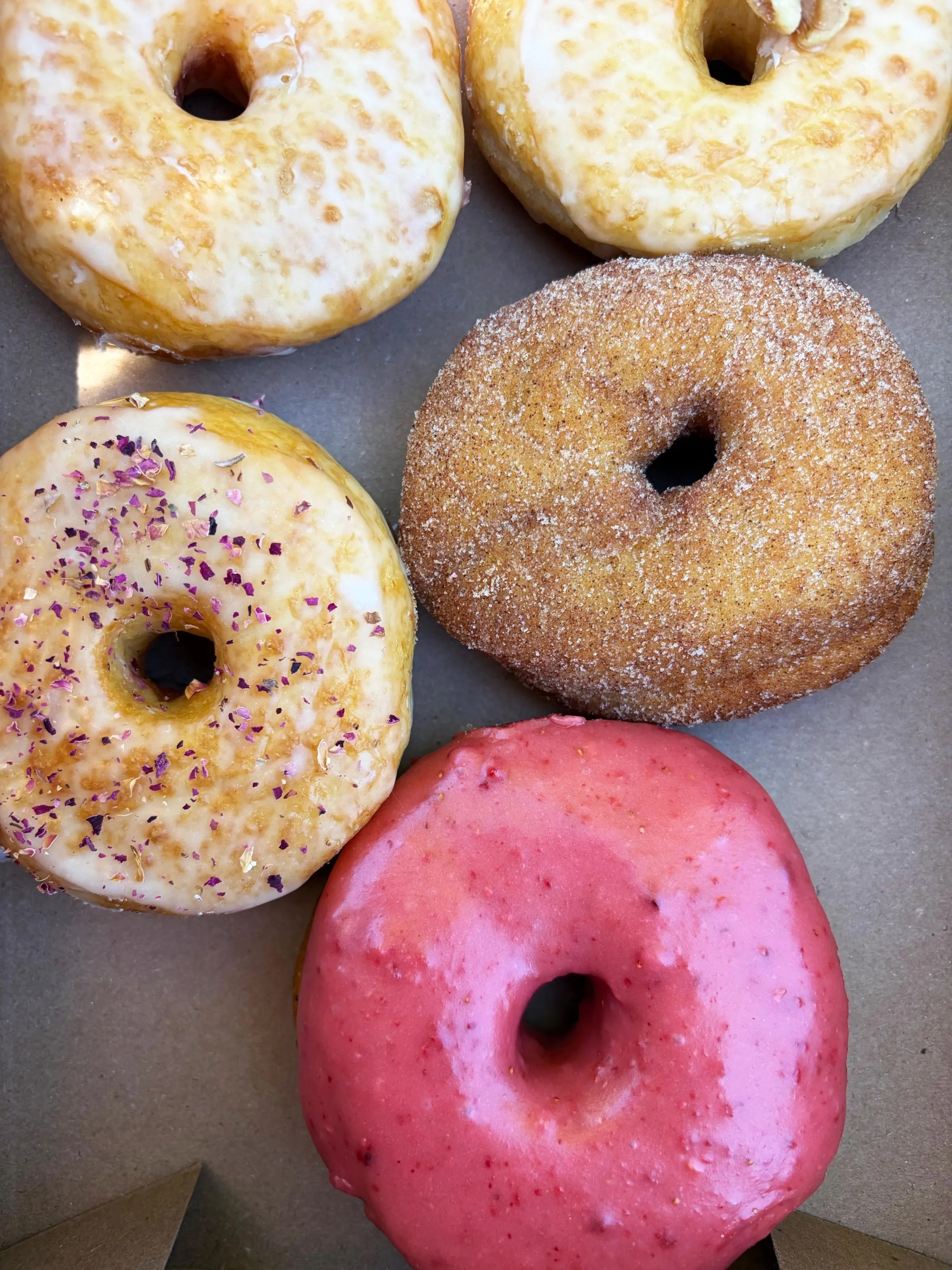 Potato doughnuts in a cardboard box at Carmack’s, including rose-petal and cinnamon-sugar rings