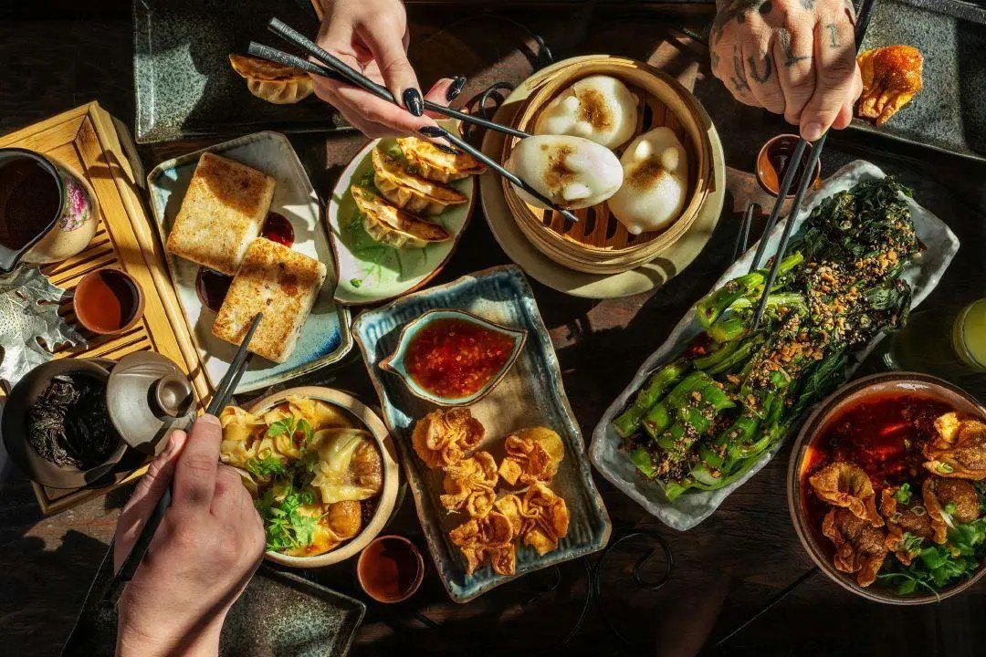 A dim-sum spread at Jade Rabbit, with bunny buns, chili-oil dumplings, and hands reaching in