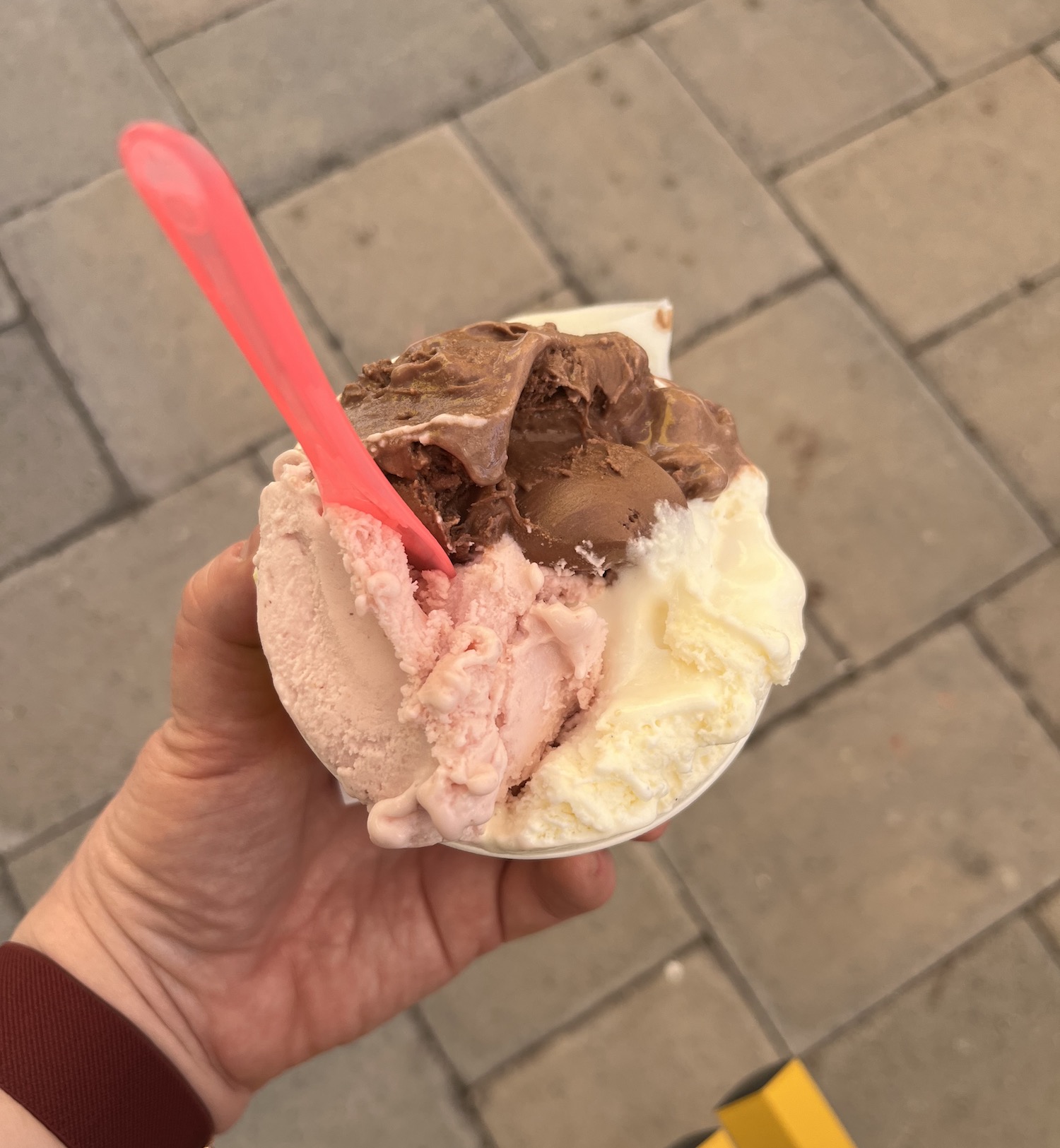 Three scoops of Pronto Gelato — chocolate, strawberry, and vanilla — in a paper cup