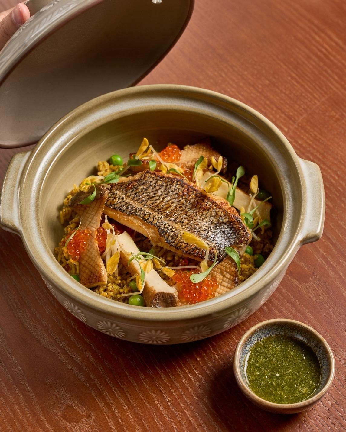 A Thai plate at Saam, with herbs and a dark sauce on a ceramic dish