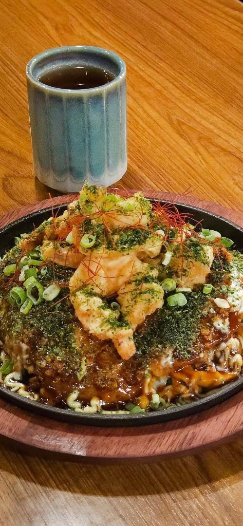 Okonomiyaki at Jiban-Ya, sauce-drenched and piled on a griddle plate
